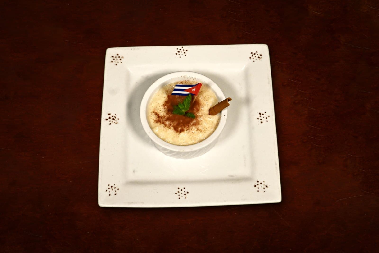 Arroz con Leche: creamy Cuban rice pudding, plated on a dark wood table